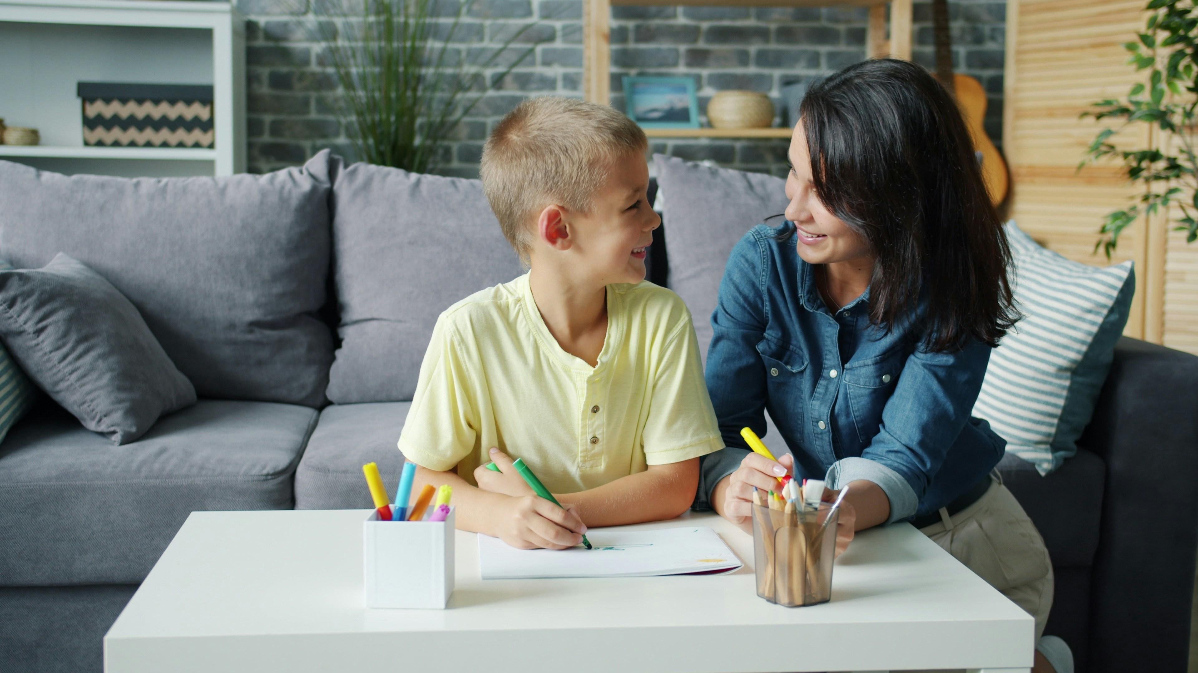 A young person and a key worker drawing together at a kitchen table at home.